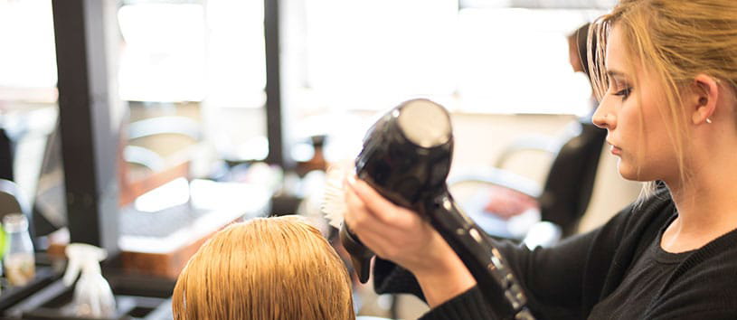 An IntelliTec College Cosmetology student practices her hair styling skills