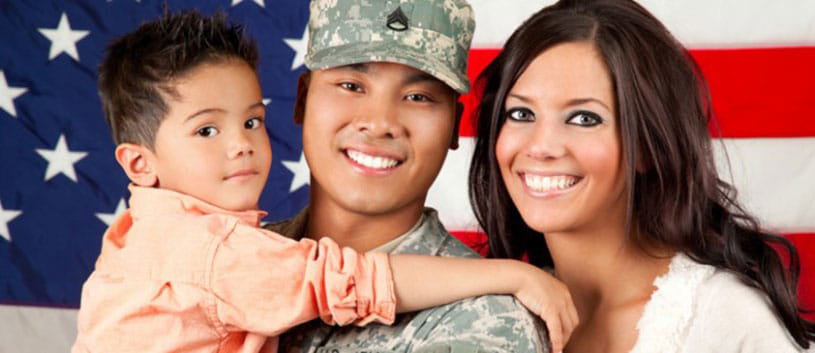 A smiling veteran with his wife and son